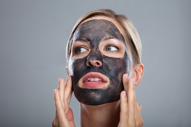 Mulher com máscara facial de carvão