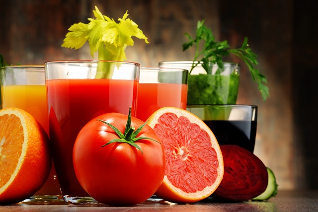 Copo com suco de tomate e laranja